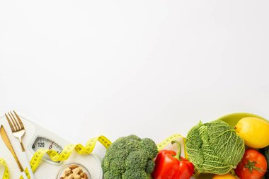 Zayıflatıcı konsept. Sebze, lahana, lahana, domates, biber, biber, çatal bıçak ve mezura fotoğraflarının üst görüntüsü.