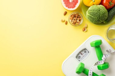Detoks konsepti. Meyve sebze, lahana, lahana, salatalık, greyfurt, su dambılı fındık, bant, izole edilmiş pastel sarı arka planda ölçü ölçer.