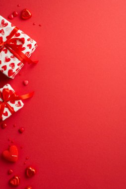 Sevgililer Günü konsepti. Mevcut kutuların dikey görüntüsü kalp şekilli şekerler mum ve kopyalanmış kırmızı arkaplan üzerine serpiştirmeler
