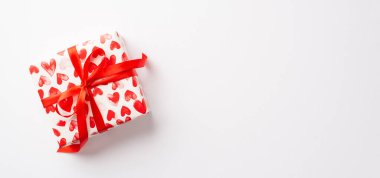 Sevgililer Günü konsepti. Yalıtılmış beyaz arkaplan üzerinde kalp desenli ambalaj kağıdındaki hediye kutusunun en üst görünümü