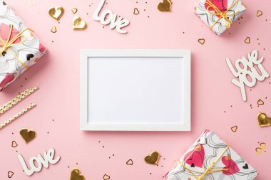 Sevgililer Günü konsepti. Fotoğraf çerçevesinin en üstteki fotoğrafı hediye kutuları, altın kalp şekilli konfeti yazıtları, izole edilmiş pastel pembe arka planda bulunan kamışları ve pulları sever.