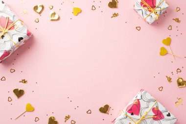 Sevgililer Günü konsepti. Hediye kutularının en üstteki fotoğrafı. Altın kalpler ve izole edilmiş pastel pembe arka plandaki pullar. Ortasında da kopyalanmış alan var.