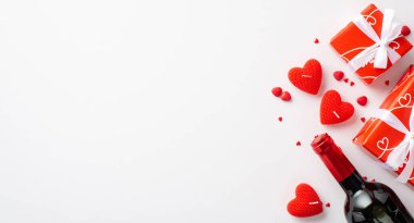 Sevgililer Günü konsepti. Kırmızı kutular, kurdele, kurdele, kalp şeklinde mumlar, şarap şişesi ve boş arkaplan üzerine serpiştirilmiş beyaz arkaplan.