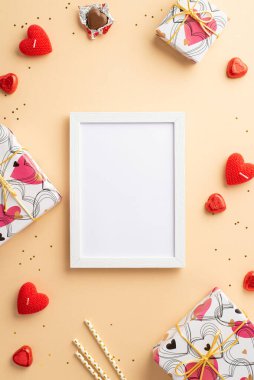 Valentine's Day concept. Top view vertical photo of photo frame gift boxes heart shaped chocolate candies straws candles and golden sequins on isolated pastel beige background with copyspace
