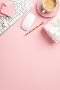 Valentine's Day concept. Top view vertical photo of keyboard computer mouse stylish pen giftbox stationery and cup of coffee on saucer on isolated pastel pink background with copyspace