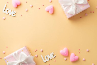 Valentine's Day concept. Top view photo of pastel pink gift boxes with white ribbon bows inscriptions love heart shaped candles and sprinkles on isolated pastel beige background with copyspace