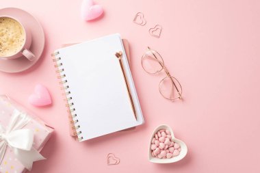 Valentine's Day concept. Top view photo of notepad stylish pen glasses heart shaped saucer with sprinkles giftbox candles and cup of coffee on isolated pastel pink background with empty space