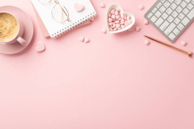 Valentine's Day concept. Top view photo of planner keyboard stylish glasses pen heart shaped saucer with sprinkles and cup of coffee on isolated pastel pink background with copyspace