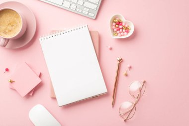 Valentine's Day concept. Top view photo of planners golden pen glasses heart shaped saucer pushpins sticky note paper keyboard and mug of coffee on isolated pastel pink background with copyspace