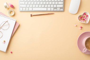 Valentine's Day concept. Top view photo of keyboard computer mouse planners pen heart shaped saucer pins decorative tape cup of coffee on isolated pastel beige background with copyspace in the middle