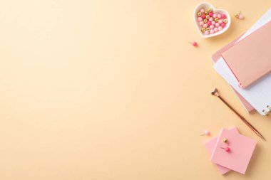8-march concept. Top view photo of stack of notepads golden pen heart shaped saucer pushpins and sticky note paper on isolated pastel beige background with copyspace