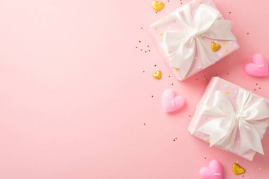 Valentine's Day concept. Top view photo of present boxes with white ribbon bows golden hearts candles and sequins on isolated pastel pink background with empty space