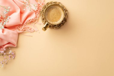 Hello spring concept. Top view photo of mug of frothy coffee on rattan placemat pink soft plaid and gypsophila flowers on isolated pastel beige background with blank space
