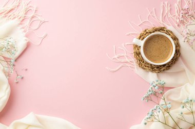 Hello spring concept. Top view photo of cup of frothy cocoa on rattan serving mat pink and blue gypsophila flowers and white soft scarf on isolated pastel pink background with blank space