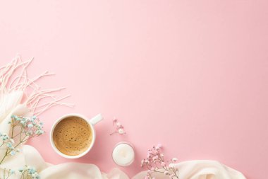 Merhaba bahar konsepti. Köpüklü kahve fincanının üst görüntüsü. Mumlar, çingene çiçekleri ve izole edilmiş pastel pembe arka planda beyaz eşarp.