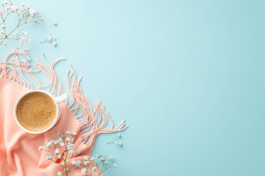 Merhaba bahar konsepti. Sıcak köpüklü kahve fincanının üst görüntüsü çingene çiçekleri ve izole edilmiş pastel mavi arka planda pembe eşarp.