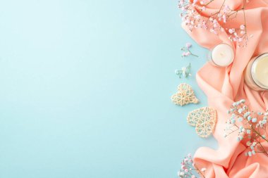 Bahar havası. En üstteki fotoğrafta, gözlüklü iki rattan kupa mumları ve izole edilmiş pastel mavi arka planda pembe yumuşak ekoseli, boş alan.