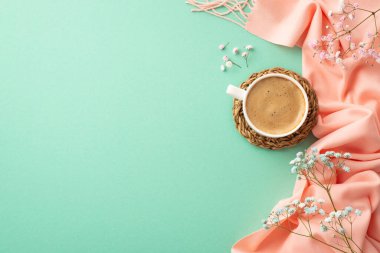 Hello spring concept. Top view photo of cup of fresh coffee on rattan serving mat gypsophila flowers and pink plaid on isolated turquoise background with blank space