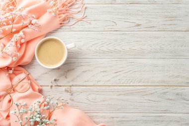 Hello spring concept. Top view photo of cup of hot drinking stylish glasses gypsophila flowers and pink plaid on grey wooden desk background with empty space