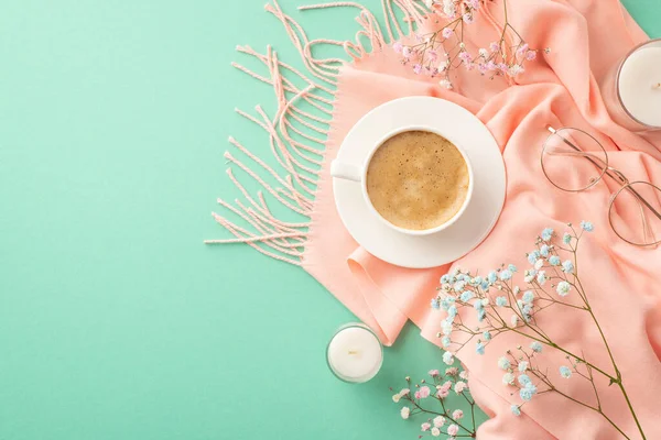 Hello spring concept. Top view photo of cup of fresh coffee on saucer gypsophila flowers stylish glasses candles and pink scarf on isolated teal background