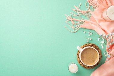 Hello spring concept. Top view photo of cup of hot drinking on rattan serving mat candles gypsophila flowers and pink plaid on isolated teal background with empty space