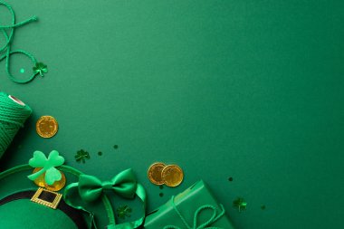 St Patrick's Day concept. Top view photo of leprechaun headwear giftbox with bow spool of twine gold coins bow-tie shamrock and trefoil shaped confetti on isolated green background with copyspace