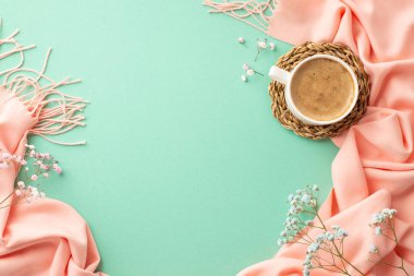 Hello spring concept. Top view photo of cup of fresh coffee on wicker placemat gypsophila flowers and pink scarf on isolated turquoise background with blank space
