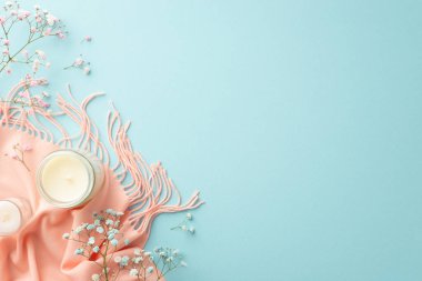 Hello spring concept. Top view photo of candles gypsophila flowers and pink scarf on isolated pastel blue background with copyspace