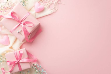 Saint Valentine's Day concept. Top view photo of pink gift boxes with bows white soft scarf heart shaped candles and gypsophila flowers on isolated pastel pink background with blank space
