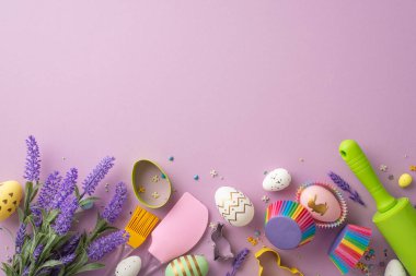 Easter preparation concept. Top view photo of kitchen utensils bunch of lavender flowers colorful easter eggs in paper baking molds and sprinkles on isolated lilac background with blank space