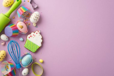 Easter concept. Top view photo of whisk rolling pin colorful easter eggs cupcake shaped gingerbread and paper baking molds with sprinkles on isolated pastel violet background with copyspace