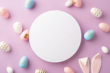 Paskalya konsepti. Beyaz, boş, renkli paskalya yumurtalarının ve yalıtılmış leylak arkaplanlı paskalya tavşanı kulaklarının en üstteki fotoğrafı.