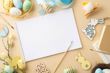 Paskalya konsepti. Albüm boyalarının en üst görüntüsü renkli paskalya yumurtaları kase ahşap dekor mavi kurdele tavuk yuvası notları ve izole edilmiş bej arka planda paskalya buketi.