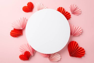 Anneler Günü konsepti. Beyaz daire ve origami kağıt kalplerin üst görüntüsü izole edilmiş pembe arkaplan ve boş alan