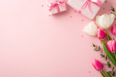 Anneler Günü konsepti. Mevcut kutular, kurdele kurdeleleri, bahar çiçeği buketleri ve izole edilmiş pastel arkaplan üzerine kalp şeklinde serpiştirilmiş kopyalanmış pembe arkaplan resimleri.