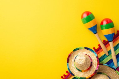 Cinco-de-mayonez karnavalı konsepti. Sombrero rengarenk panço ve izole edilmiş, sarı arka planda, boş alan olan birkaç marakas.