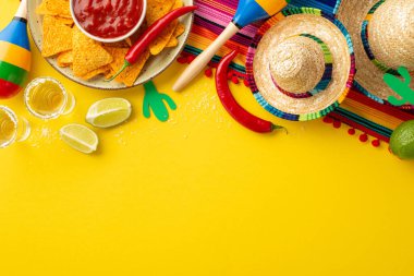 Cinco-de-mayonez konsepti. Nacho cipsli tekila dilimlenmiş limon kabuğunun üst görüntüsü. Acı biber sosu. Sombrero serape kaktüs siluetleri.