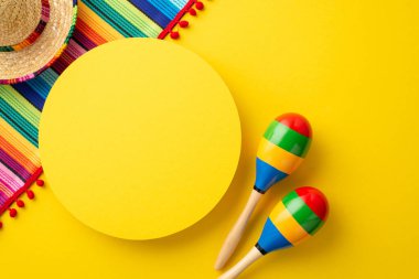 Meksika geleneksel tatil konsepti. Sarı daire sombrero renkli serape ve marakaların izole edilmiş parlak sarı arkaplanlı fotosu.