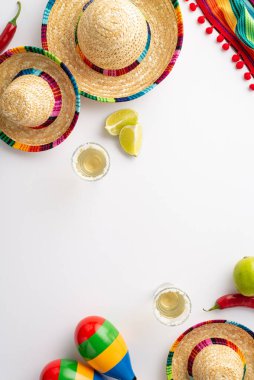 Cinco de Mayo 'yu bir sombrero, panço ve marakas' ın eğlenceli ve şenlikli dikey görüntüsüyle kutlayın, artı tekila shot 'ları, limon dilimleri, kırmızı biberler beyaz arka planda kopyalanmış