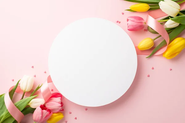 stock image 8-march concept. Top view photo of white circle bunches of yellow pink white tulips satin ribbon and sprinkles on isolated pastel pink background with blank space