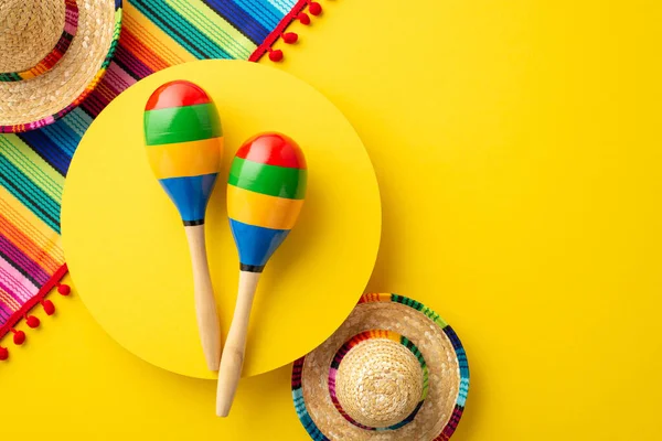 stock image Cinco-de-mayo carnival concept. Top view photo of couple of maracas over yellow circle traditional costume sombrero hats and colorful striped serape on isolated vivid yellow background