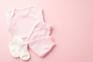 Bebek kıyafetleri konsepti. Pembe gömlekli pantolon ve çorapların üst manzara fotoğrafı. Kopyalama alanı ile izole edilmiş pembe arka plan.