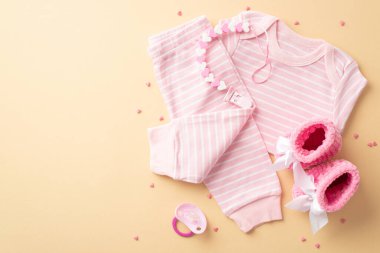 Bebek kız konsepti. Bebek kıyafetlerinin üst görüntüsü pembe gömlek pantolonlar örülmüş paçalar izole edilmiş pastel sarısı arka plan üzerine bağlar ve serpiştirir boş alan