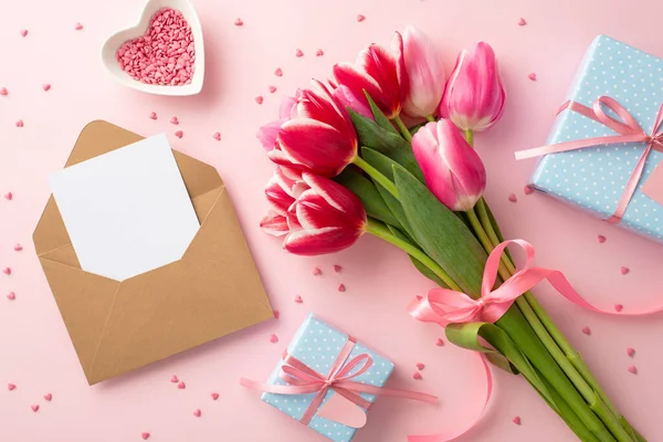 stock image Mother's Day concept. Top view photo of bouquet of tulips blue gift boxes craft paper envelope with letter and heart shaped saucer with sprinkles on isolated pastel pink background with copyspace