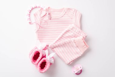 Bebek partisi konsepti. Pembe bebek kıyafetleri, pantolon, zincir ve izole edilmiş beyaz arka planda örülmüş ayaklar.