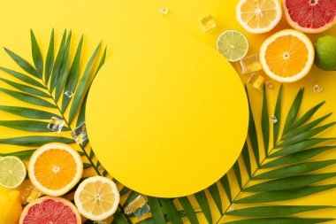 Yaz temalı düz fotografta turunçgil, limon, limon ve greyfurt renginde taze yeşil palmiye yaprakları ve yazı veya markalaşma için boş bir daire yer alıyor.