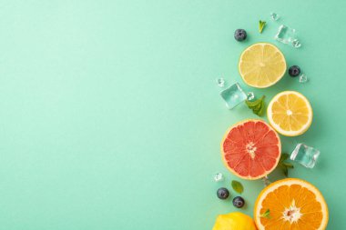 Turunçgil cenneti konsepti. Turkuaz zemin üzerinde portakal, limon, limon ve greyfurt manzarası reklam veya logo için boş alan