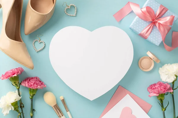 stock image Celebrate Mother's Day with this stunning top view flat lay photo of high-heels, earrings, makeup brushes, and a gift box surrounded by pretty carnation flowers on a pastel blue background with empty heart for text