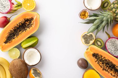 Ada kaçış konsepti. Beyaz bir arka planda tropikal meyve, kivi, papaya, ananas, portakal, limon, mango ve hindistan cevizi manzarası ve pazarlama için boş bir alan.