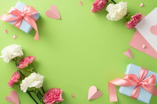母亲节的概念 顶部平铺着粉色礼品盒 康乃馨花和粉色纸心 衬托在柔和的淡绿色背景上 空旷的空间 — 图库照片